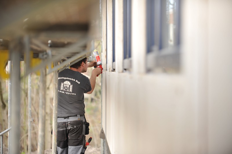 Mitarbeiter bringt Silikondichtung am Fenster an