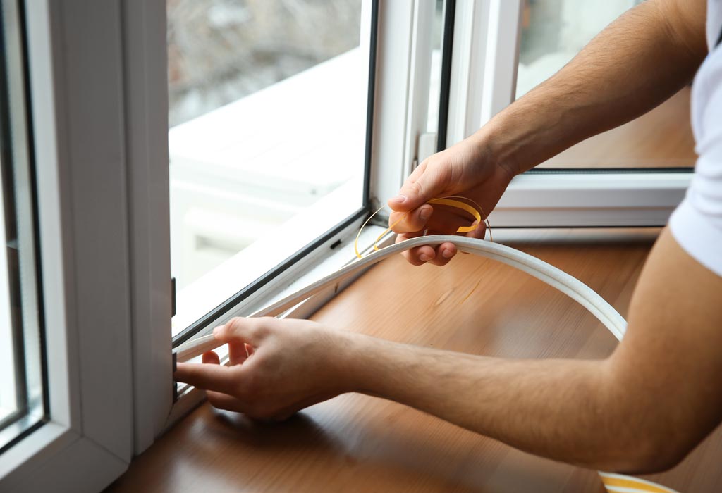 Young worker installing window in flat